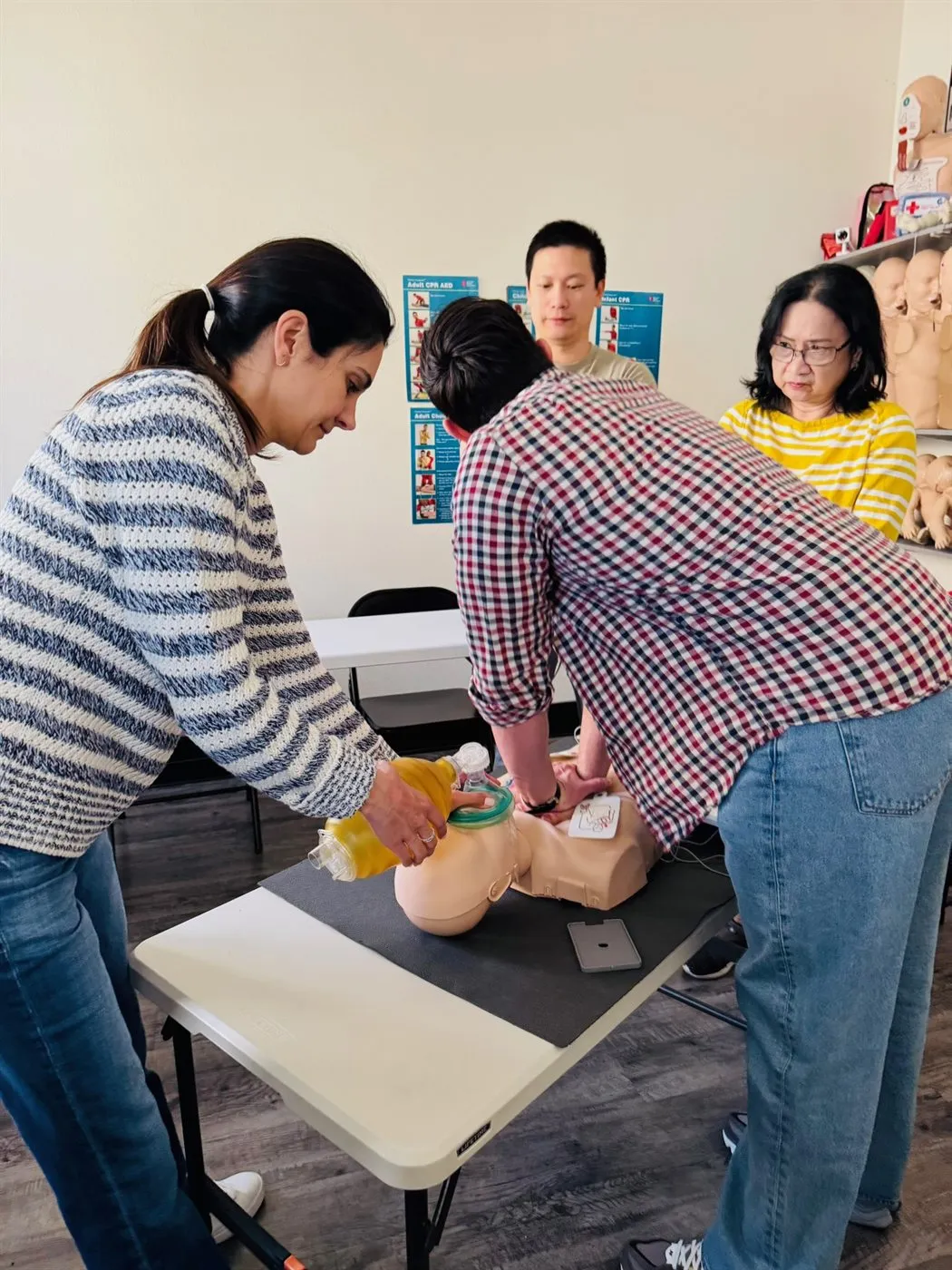 Adriana Park, MSN, RN teaching a hands-on CPR class as students practice compressions on a training manikin